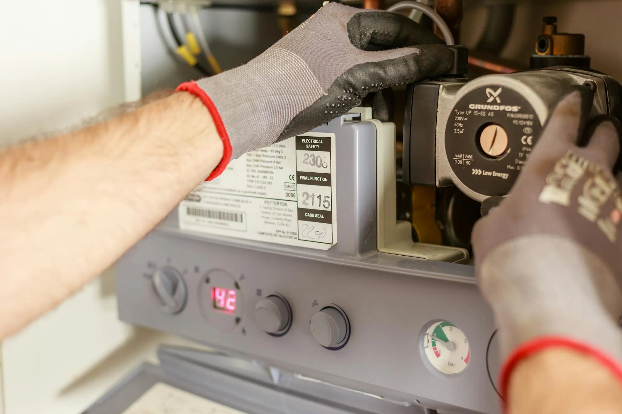 Plumber's gloved hands servicing a Potterton boiler in a Luton home